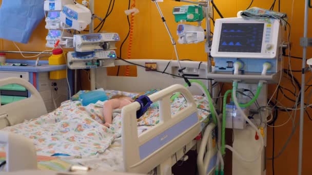 1人の子供が近代的な病棟の医療ベッドで眠る. — ストック動画