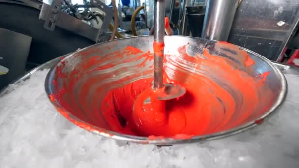 Roterende apparatuur mengt rode voedsel kleuren in een kom. — Stockvideo
