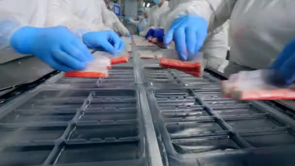 Las mujeres empaquetan los contenedores con la comida cerca de la planta . — Vídeo de stock