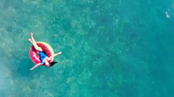 Chica flota en una piscina en un anillo de goma . — Vídeo de stock