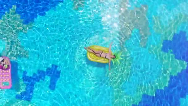 Uma mulher descansa em um colchão em uma piscina . — Vídeo de Stock