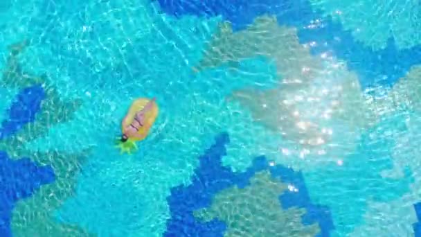 Female tourist relaxes in a pool, floating on a mattress. — Stock Video