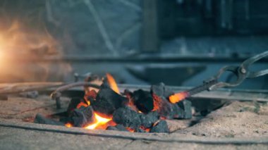 Onlar ısıtırken bir demirci kömür taşır.