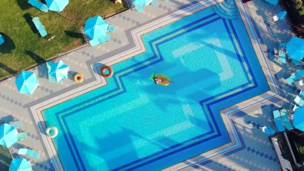 Mujer joven nada en un colchón en una piscina . — Vídeos de Stock