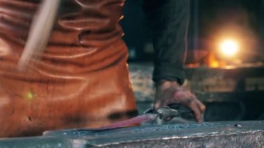 Bir kişi metal nesneye vurur, bir Forge bir çekiç ile şekillendirme.