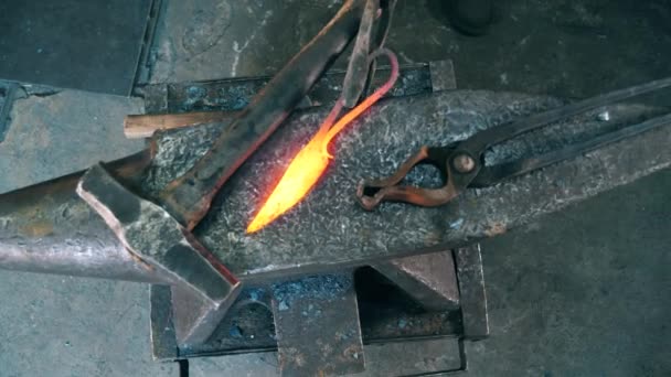 Working blacksmith puts a hot knife on an anvil. — Stock Video