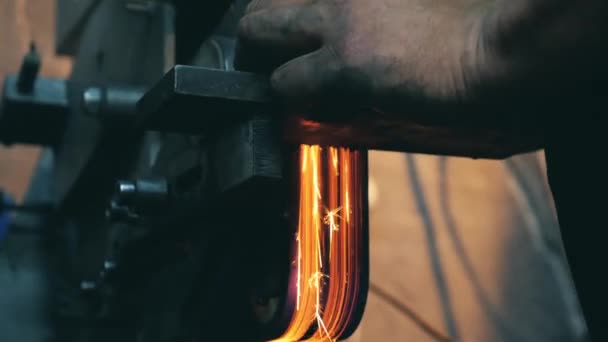 Un herrero usa amoladora angular mientras trabaja en una forja . — Vídeos de Stock