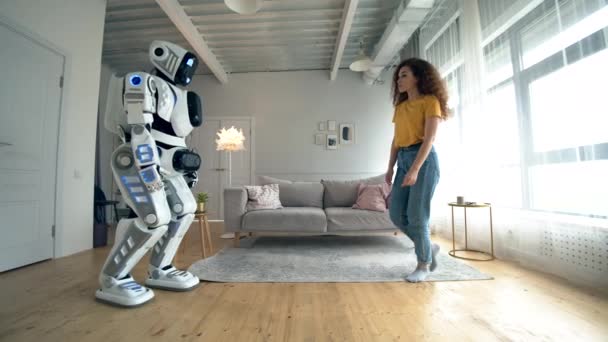 Cyborg en Human concept. Een vrouw raakt witte Droid, staande in een kamer. — Stockvideo