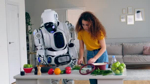 Junge Frau und ein Cyborg kochen gemeinsam Abendessen. Roboter, Cyborg und menschliches Konzept. — Stockvideo