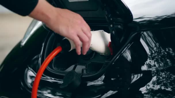 Electrical fuel nozzle is getting taken out from the car — Stock Video