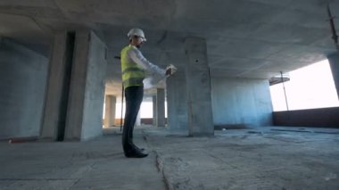 İnşaat işçisi tamamlanmamış binada duruyor. Steadicam vurdu.