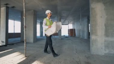 İnşaatçı, mimar bir bina planına bakıyor, yakın çekim.
