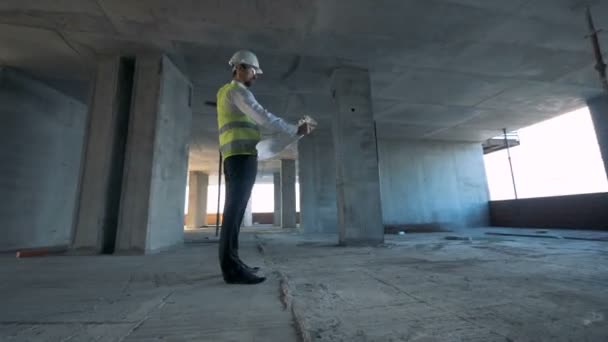 Trabajador de la construcción se encuentra en un edificio sin terminar. Steadicam tiro . — Vídeo de stock