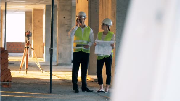 Ingenieros, arquitectos que trabajan en un edificio, obra . — Vídeo de stock