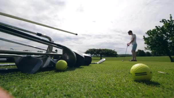 Человек играет в гольф на поле, держа металлический клуб . — стоковое видео