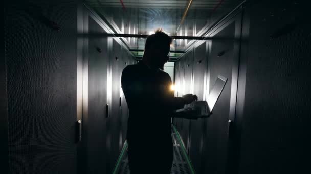 노트북을 운영하는 남성 기술자가있는 어두운 서버 룸. It 네트워크 보안 개념. — 비디오