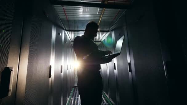 Φωτισμένη μηχανικός υπολογιστών δουλεύει στο δωμάτιο του σέρβερ — Αρχείο Βίντεο