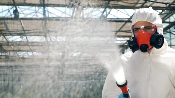 Bir hortum döküm kimyasallar ile güvenlik giyim erkek agronomist — Stok video