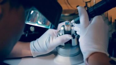 Erkek kuyumcu bir yüzük ile çalışırken bir araç kullanır. Kuyumcu, profesyonel bir mücevher atölyesinde kuyumcu.