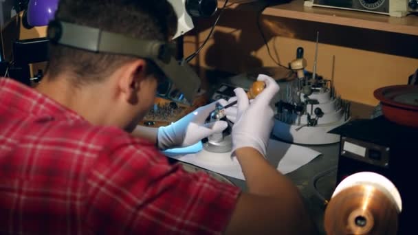 Juwelier arbeitet in Schmuckwerkstatt mit blauem Ring. — Stockvideo