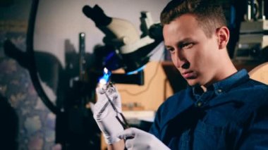 Bir kuyumcu altın yüzük ile çalışırken bir brülör kullanır.