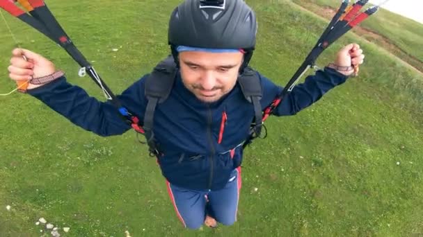Muž v helmě řídí svůj paraglider. Paraglider létající. — Stock video