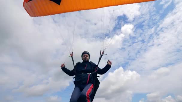 Homem está gerenciando seu parapente enquanto se move ao longo do céu — Vídeo de Stock