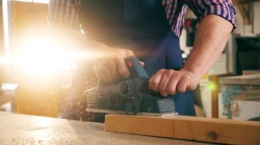 Jigsaw yavaş çekimde ahşap bir blok işliyor