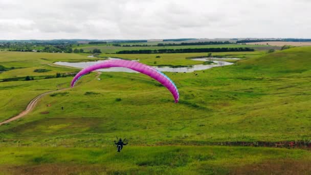 Campo enorme com o parapente a correr e a voar. Conceito de desporto extremo . — Vídeo de Stock