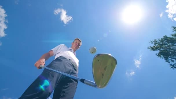 Un homme jongle avec une balle et un club sur un terrain . — Video