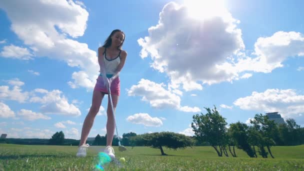 Vrouwelijke golfer raakt een bal, staande op een veld. Golfer speelt golf, sport lifestyle concept. — Stockvideo