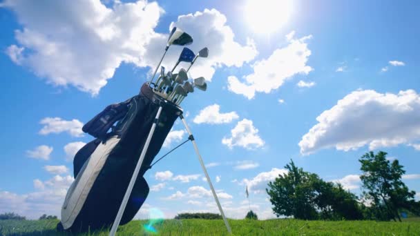 Schwarze Tasche mit Golfschlägern auf Himmelshintergrund. — Stockvideo