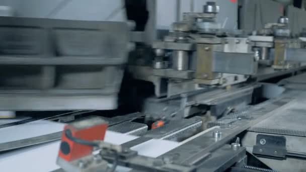 El transportador de metal trabaja con papel blanco en una sala tipográfica . — Vídeo de stock