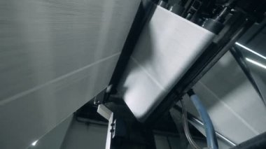 Baskı ofisinde haddeleme konveyörü üzerinde giden kağıt.