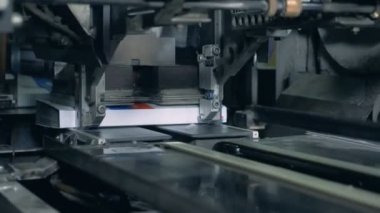 Tipografik makine bir konveyör üzerinde kitap presler.