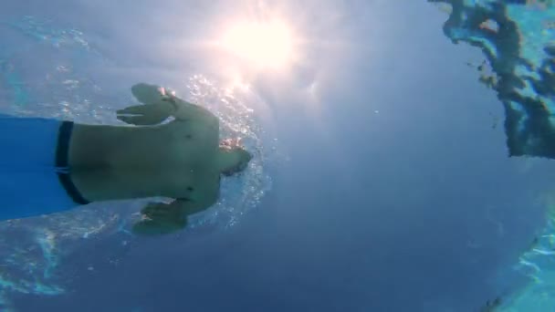 Güneş ışığı ve sualtı görünümünde bir yüzme adam — Stok video