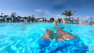 Bacaklarını hareket ettiren bir kişi ile yüzme havuzunun yüzeyi