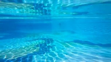 Havuzun su yüzeyi ve güneş gözlüğü atan bir kişi