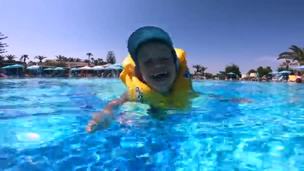 Счастливый ребенок плавает в спасательном жилете — стоковое видео