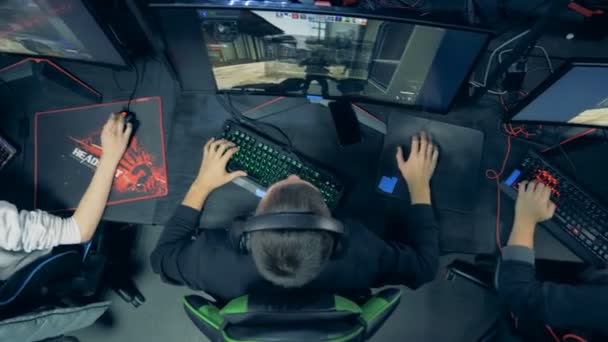 Вид сверху мужчин в компьютерном клубе, играющих в видеоигру — стоковое видео