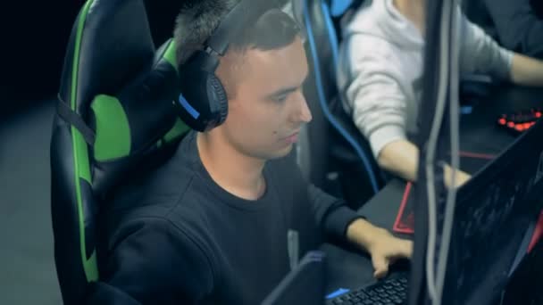 Man in een headset speelt een netwerk video game — Stockvideo