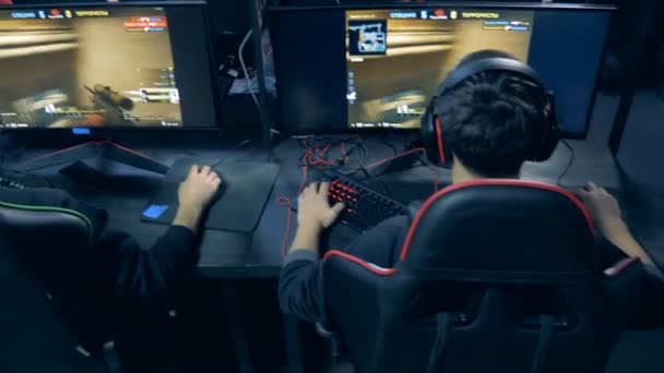 Junge Männer spielen ein Shooting-Videospiel in einer Rückansicht — Stockvideo