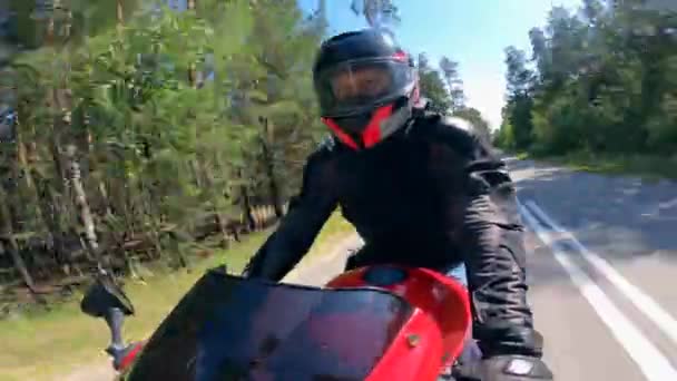 Pessoa montando uma motocicleta rápida em uma estrada perto de árvores . — Vídeo de Stock