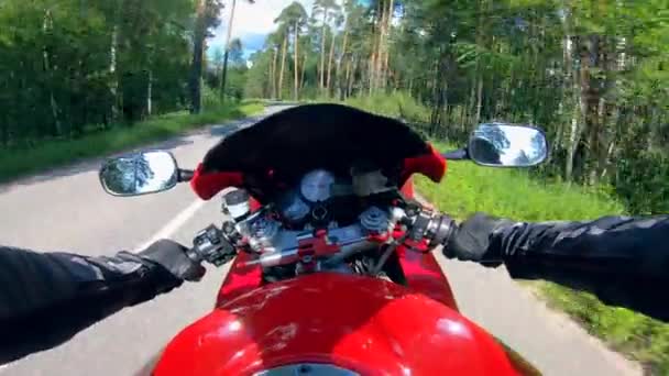 Un motociclista montando una bicicleta roja, sosteniendo asas . — Vídeo de stock