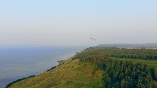La côte et un voilier glissant le long de celle-ci. Skydiver vole dans le ciel . — Video