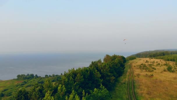 Podél pobřeží pluje vzduchový padák. Skypotápěč létá na obloze. — Stock video