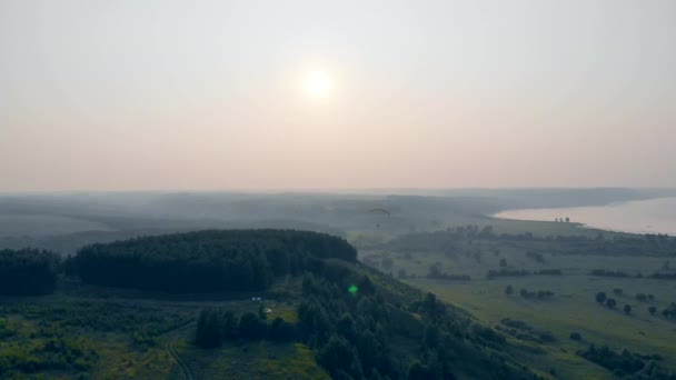Fallschirmspringer fliegt in den Himmel. Wälder und Ebenen mit einem Rammluft-Fallschirm, der über ihnen schwebt — Stockvideo