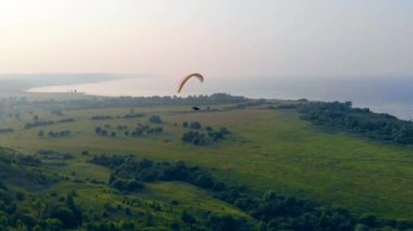 Parafoil tarlaların ve suyun üzerinde sürükleniyor.