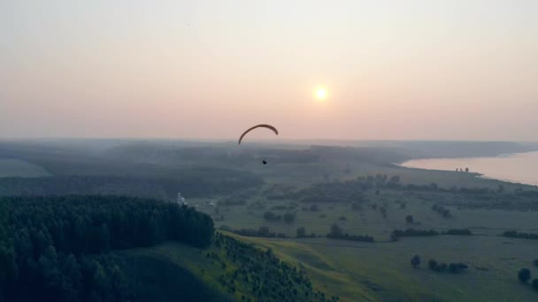 Paraplane glisse au-dessus du paysage ensoleillé brumeux. Parachute, parapente comcept . — Video