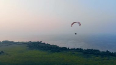 Parawing suyun üzerinde yüksekte süzülüyor. Skydiver gökyüzünde uçar.